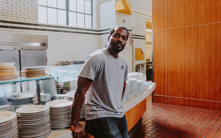 Farmacy Food owner Kwaku Osei leaning against his restaurant kitchen countertop