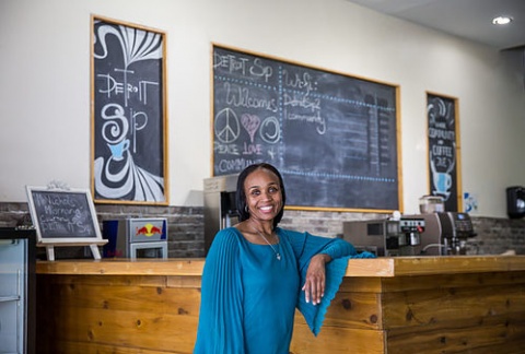 Jevona Watson, owner of Detroit Sip coffeeshop leaning against the barista bar