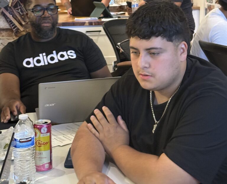 diverse business owners work on computers at a table together