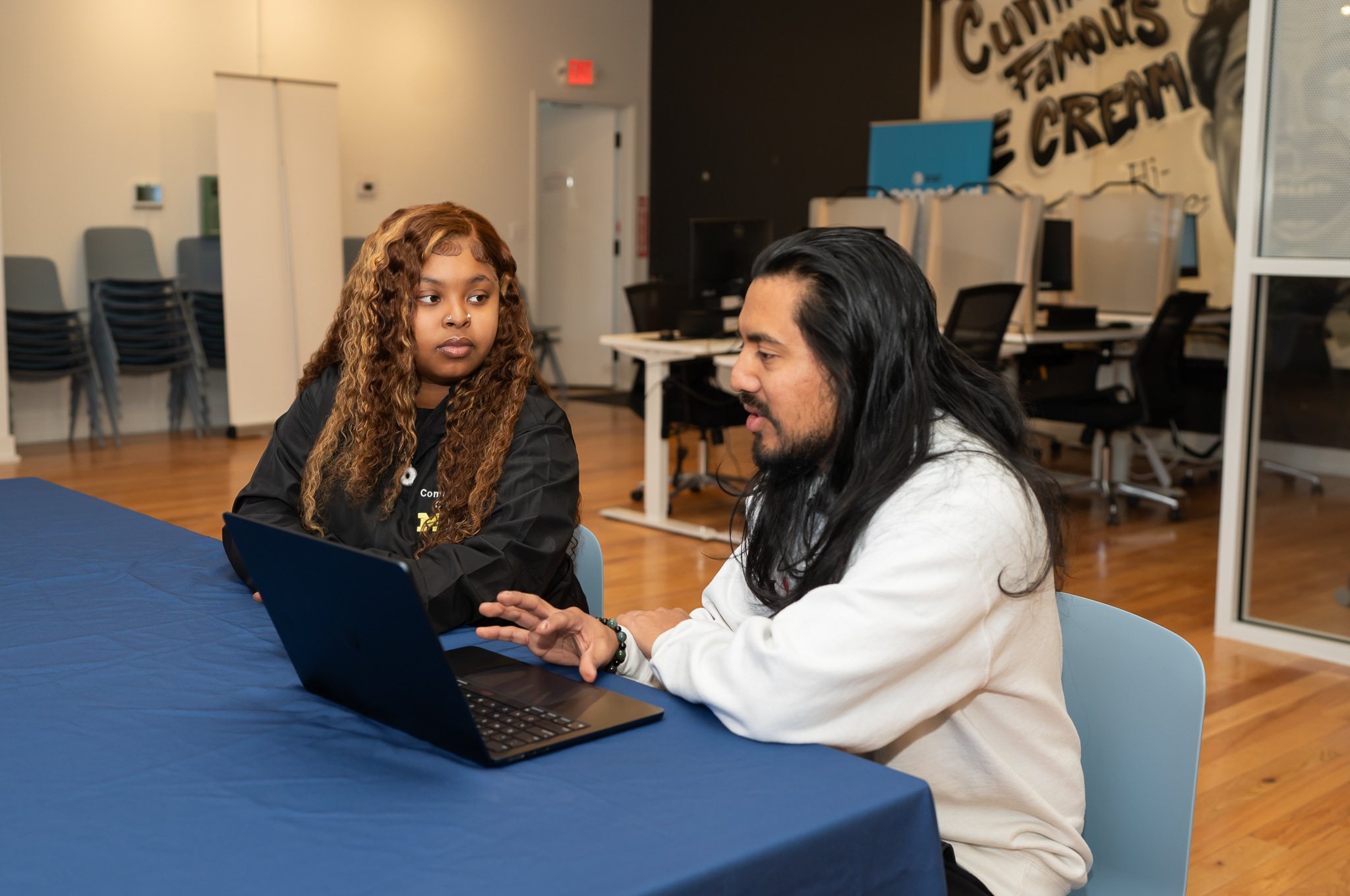 JEI Community Tech consultant Diamond Hatcher listens while entrepreneur Jose-David points to this laptop screen and explains his tech challenge