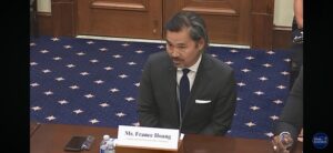 CEO France Hoang testifies before Congress, seated at a desk with a name table tent